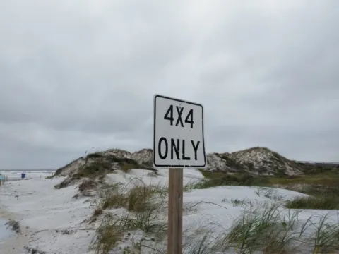 A 4x4 only sign on the dunes above the beach