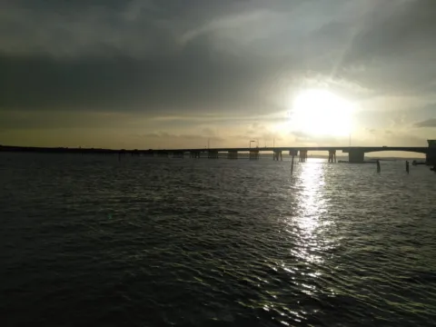 A bridge over the water at sunset