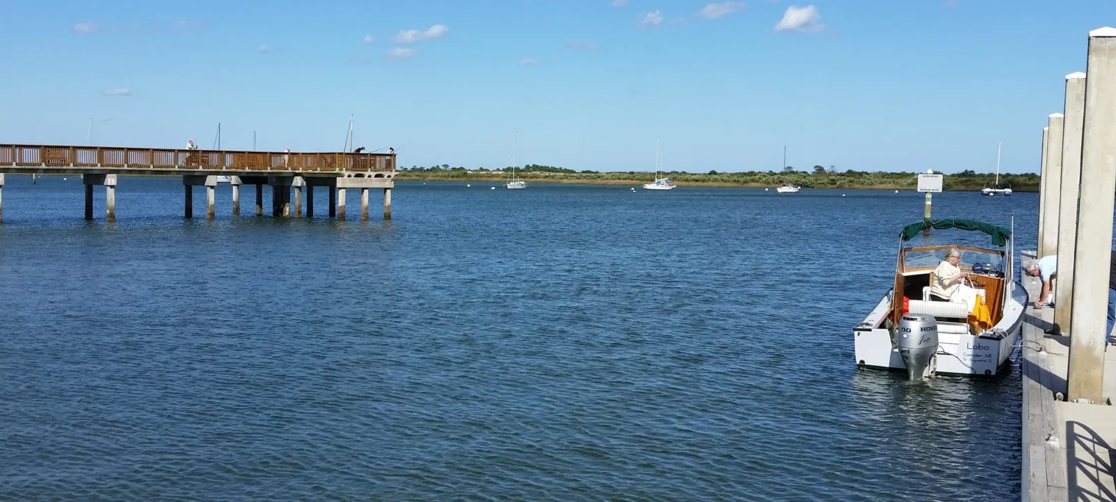 A dock and a small boat on calm water