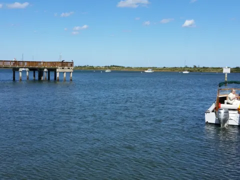 A dock and a small boat on calm water