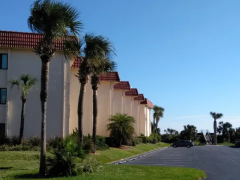 A low-rise resort building framed by palms