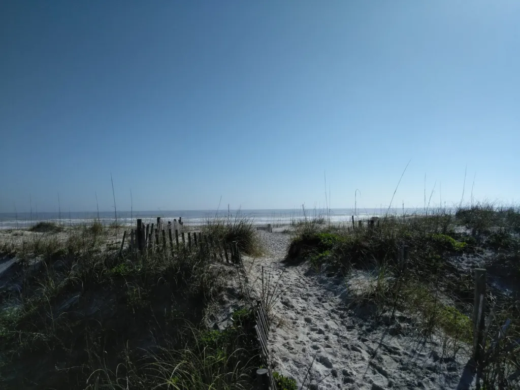 A sandy dune path leading toward the water