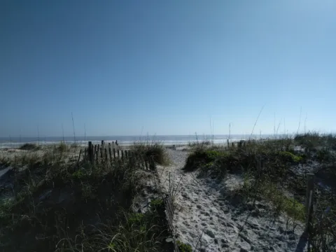 A sandy dune path leading toward the water