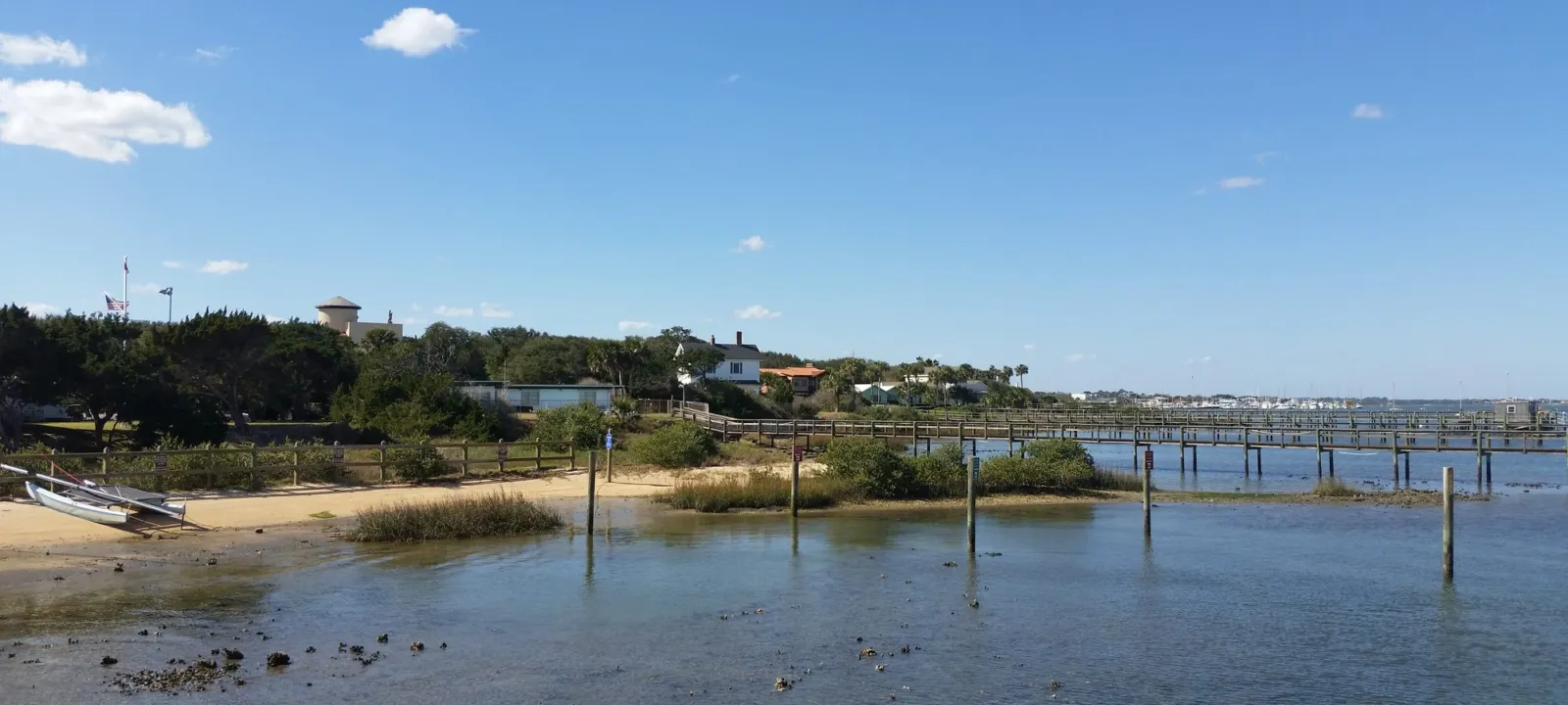 A shoreline with a pier stretching into the bay