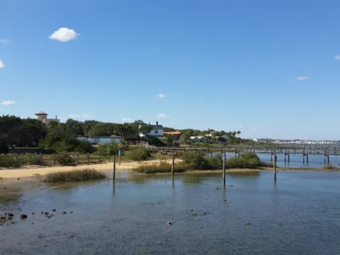 A shoreline with a pier stretching into the bay