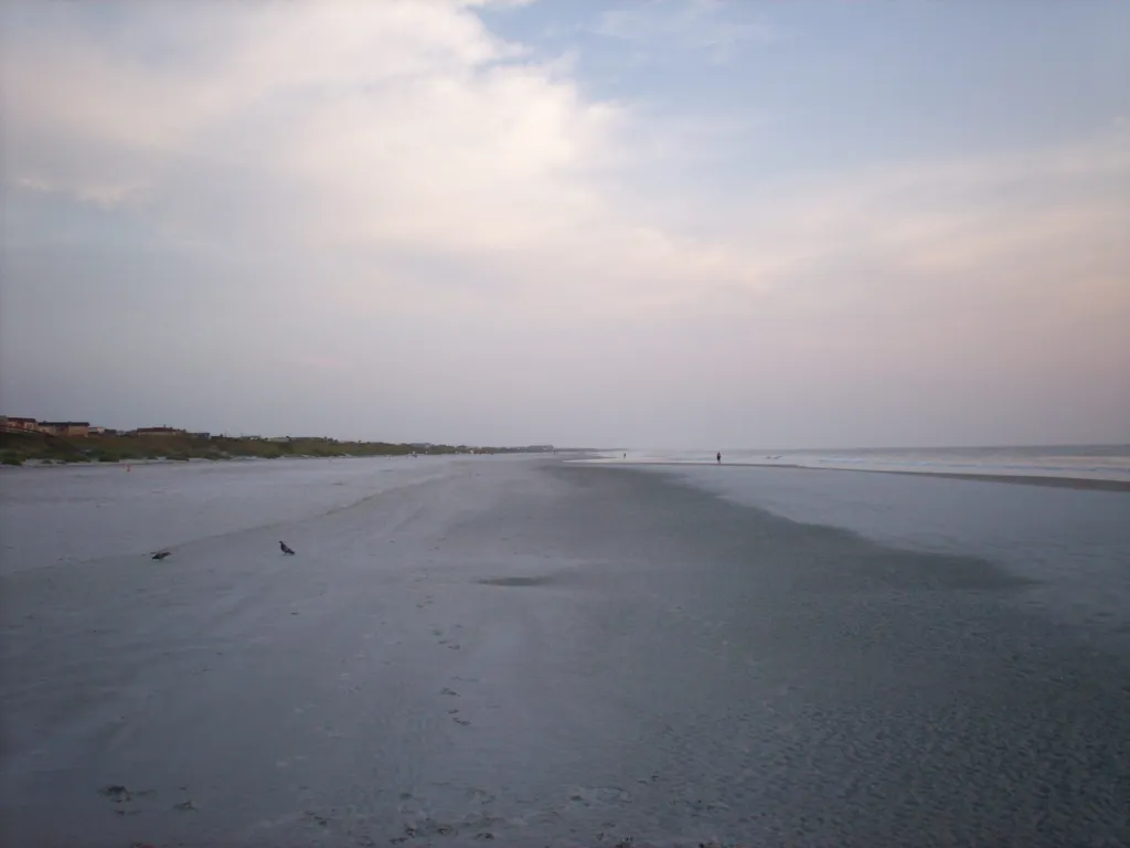 Calm water at the edge of a wide beach