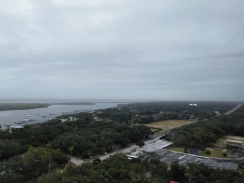 A view from above over trees, marsh and a winding river.