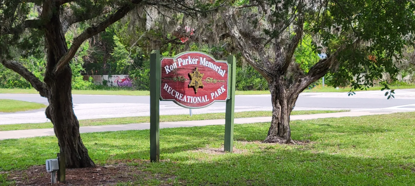 The Ron Parker Memorial Recreational Park entrance sign in St. Augustine Beach, framed by live oaks hung with Spanish moss.