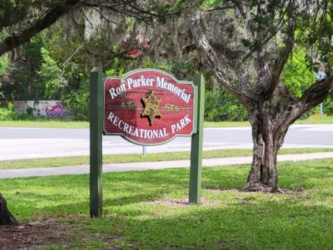 The Ron Parker Memorial Recreational Park entrance sign in St. Augustine Beach, framed by live oaks hung with Spanish moss.