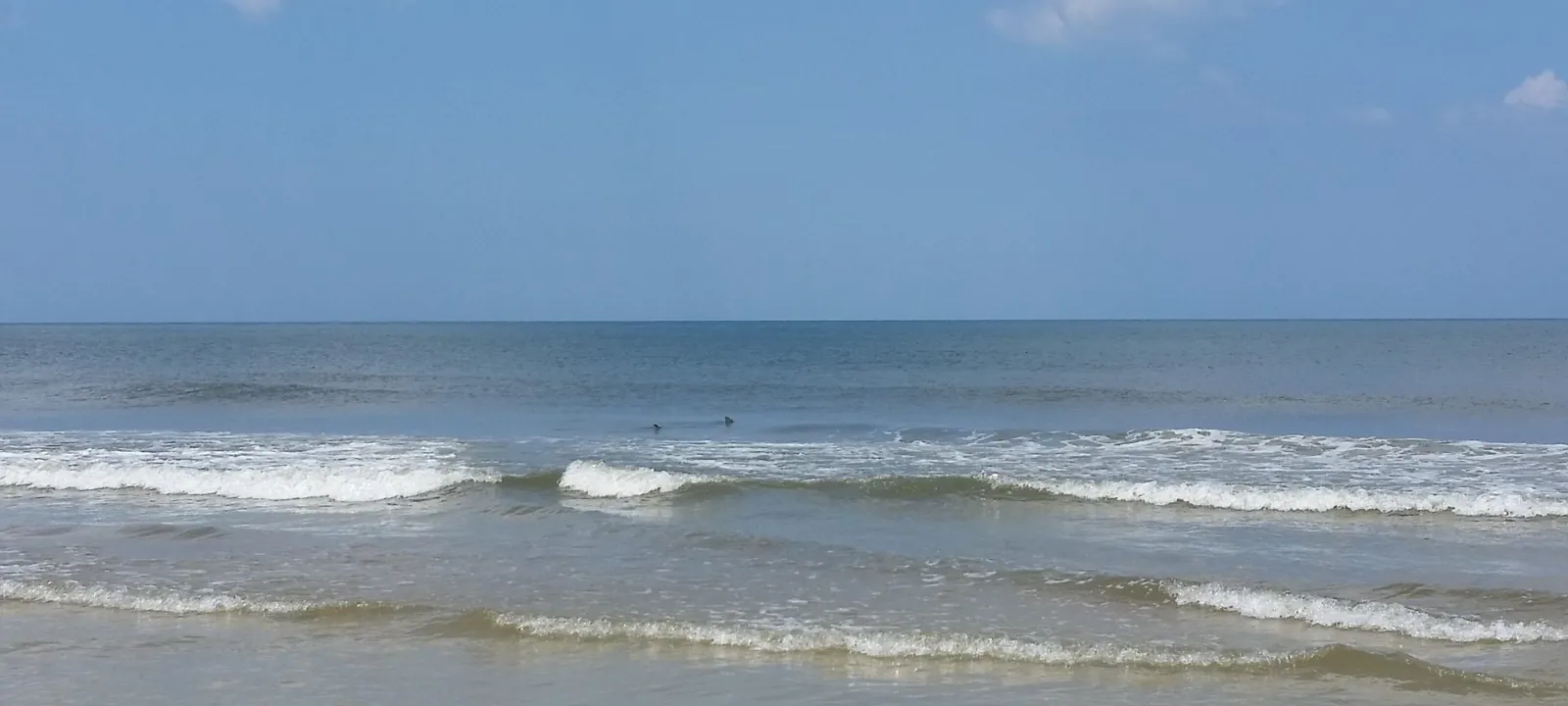 Small waves breaking on a sunny beach