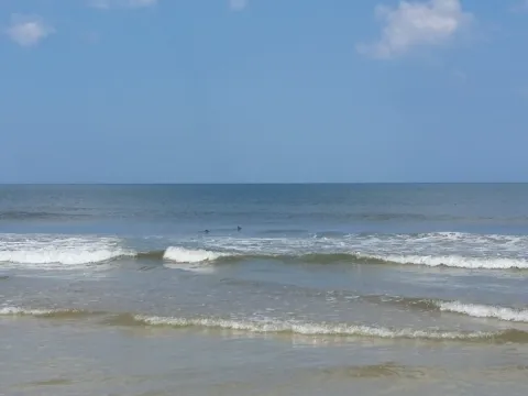 Small waves breaking on a sunny beach