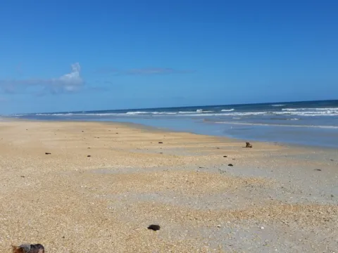 Soft waves rolling onto a beach on a sunny day.