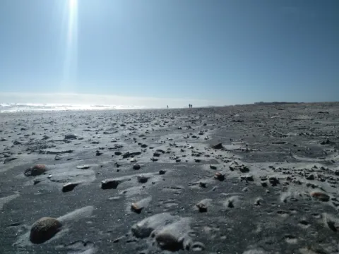 Sunlight breaking through clouds over the beach