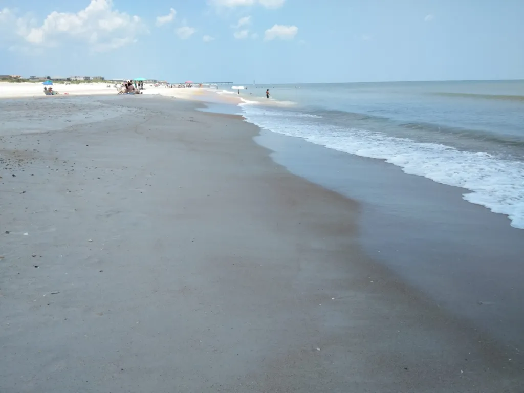 Waves washing up a wide, empty beach