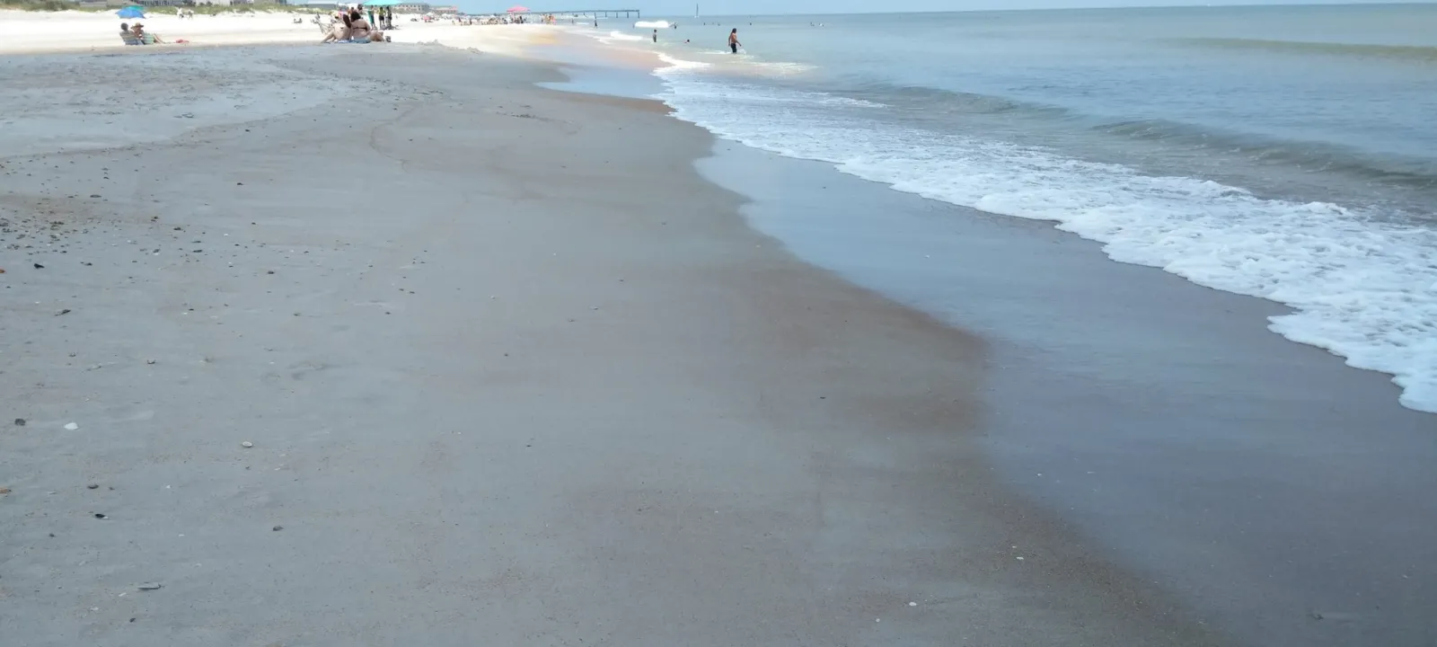 Waves washing up a wide, empty beach